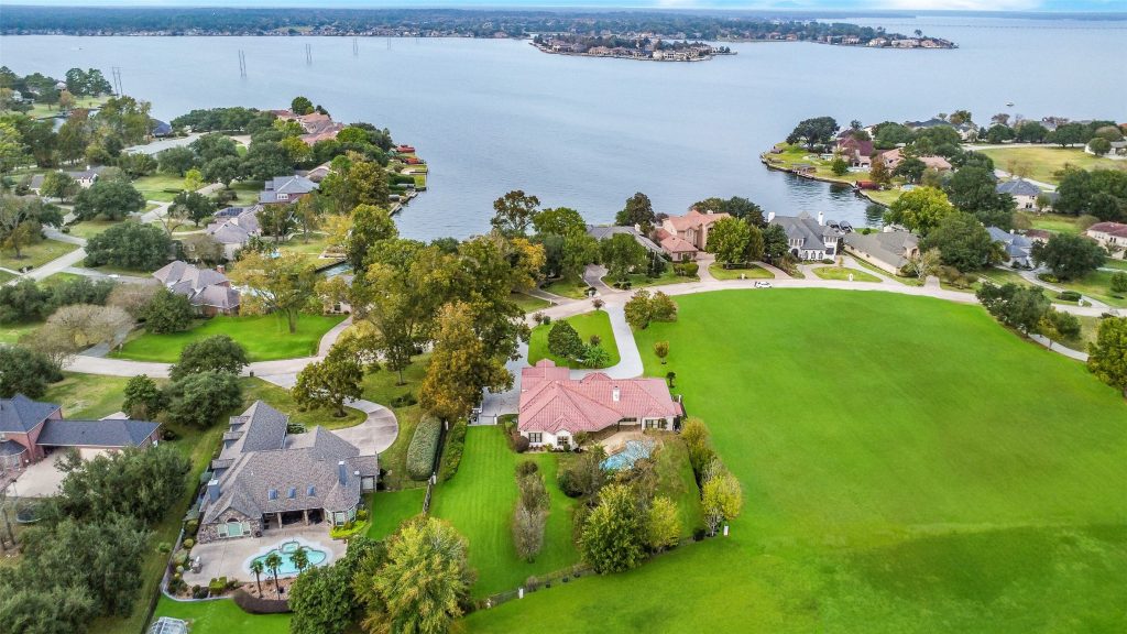 | the mckellar group Aerial View of a Luxury Neighborhood with a Green Field and the Lake in the Background