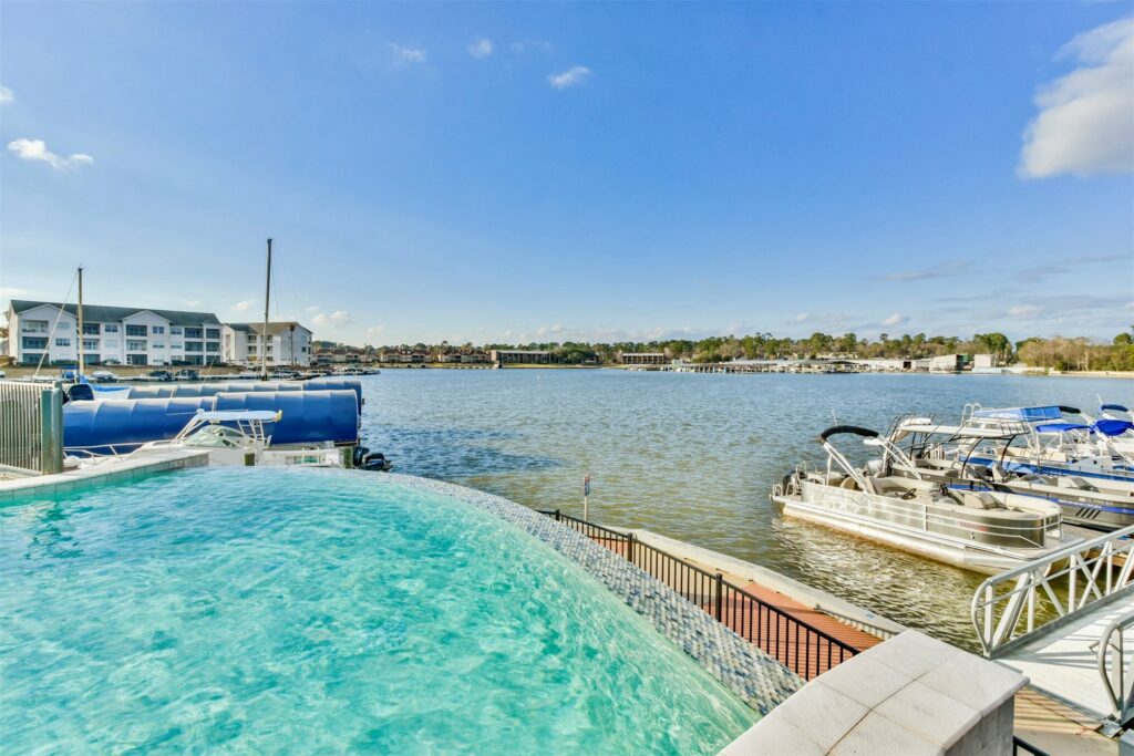 37 dsc 3625 | the mckellar group View of a Luxury Condo's pool area with the lake and docks in the background.