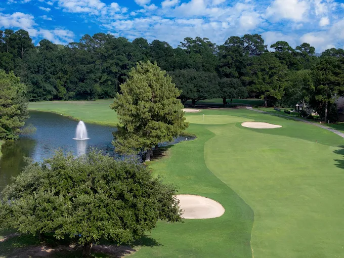 April Sound Golf Club Course with Green Fields a Water Fountain Trees and Blue Skies