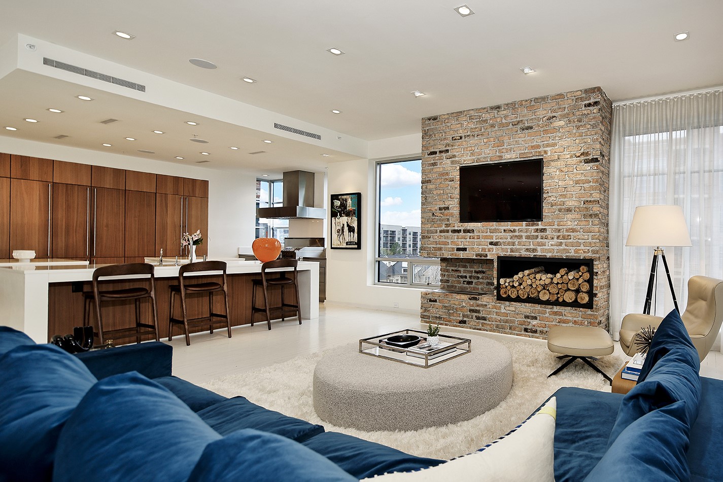 Interior View of a Luxury Condominium with a Kitchen Bar Fireplace and Views of the Woodlands from the Window