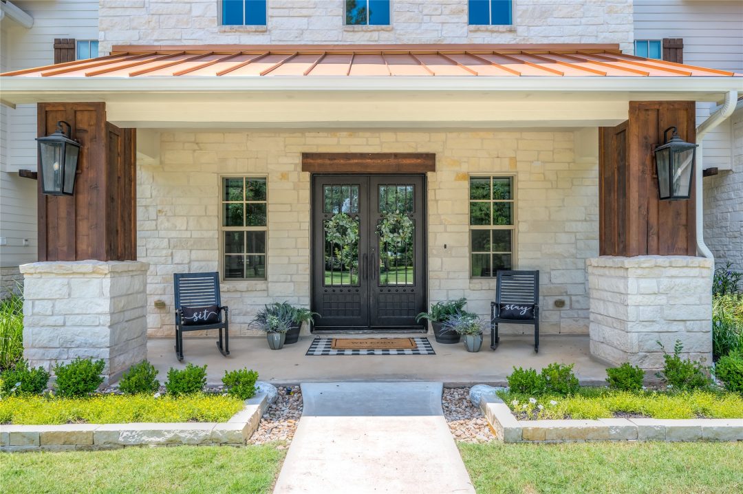 | the mckellar group Exterior View of a High End Home's entry way with a double door and neatly decorated porch.