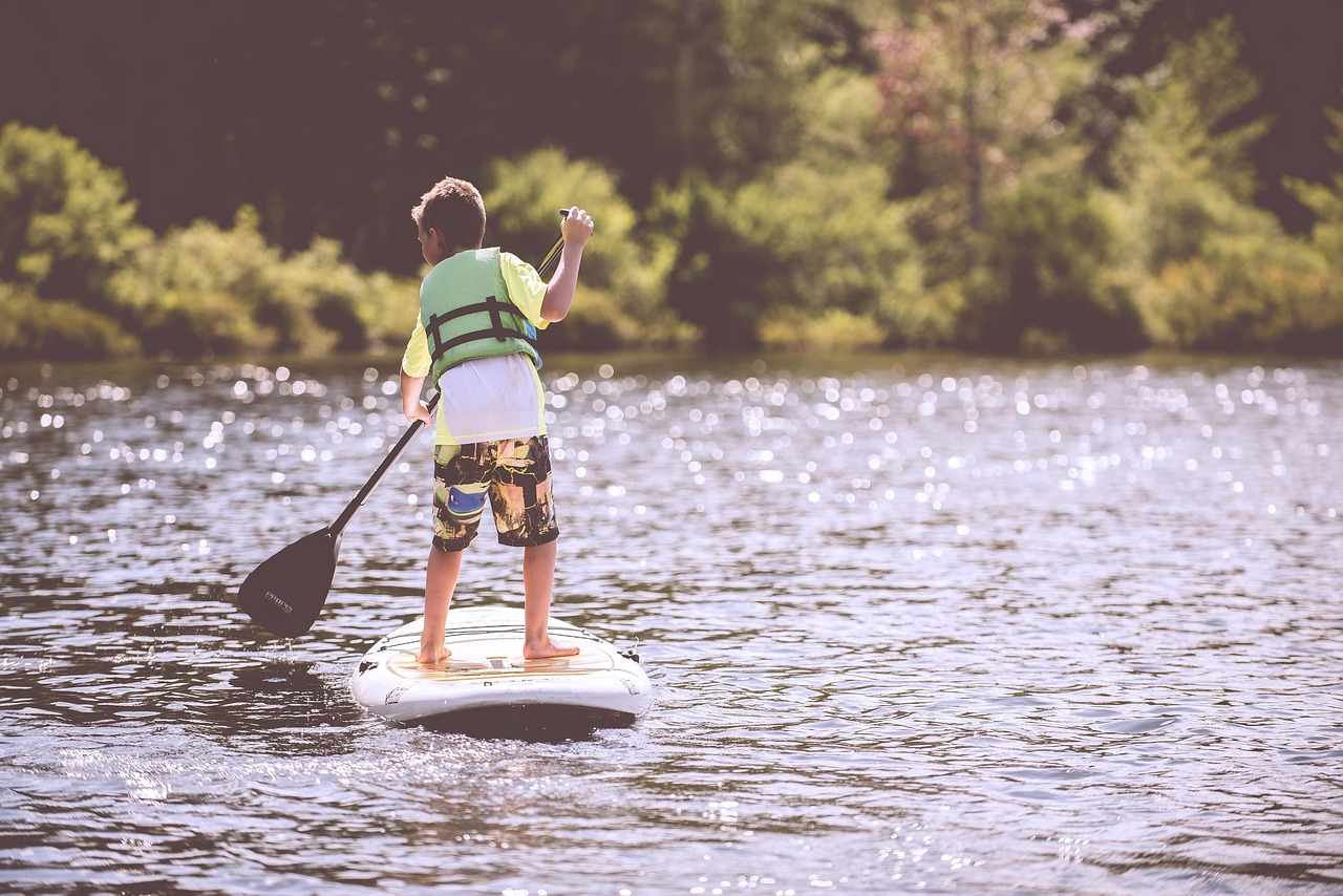 | the mckellar group Photographic Image of a Young Boy Paddleboarding on a Lake