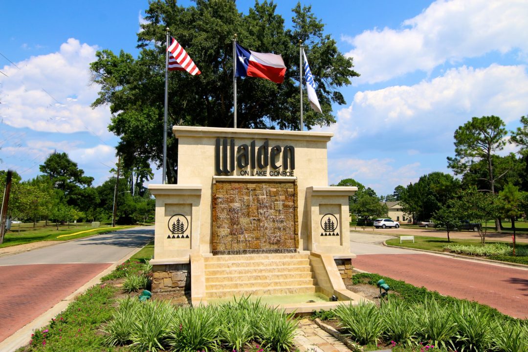 the Walden on Lake Conroe Entrance with the American Flag and Lone Star Flag