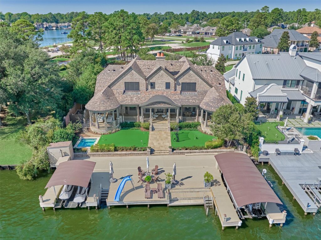 14 004 004 100 bentwater bay dr | the mckellar group Aerial View of a Waterfront Neighborhood with Houses Docks and a Backyard Pool and Deck over Green Water