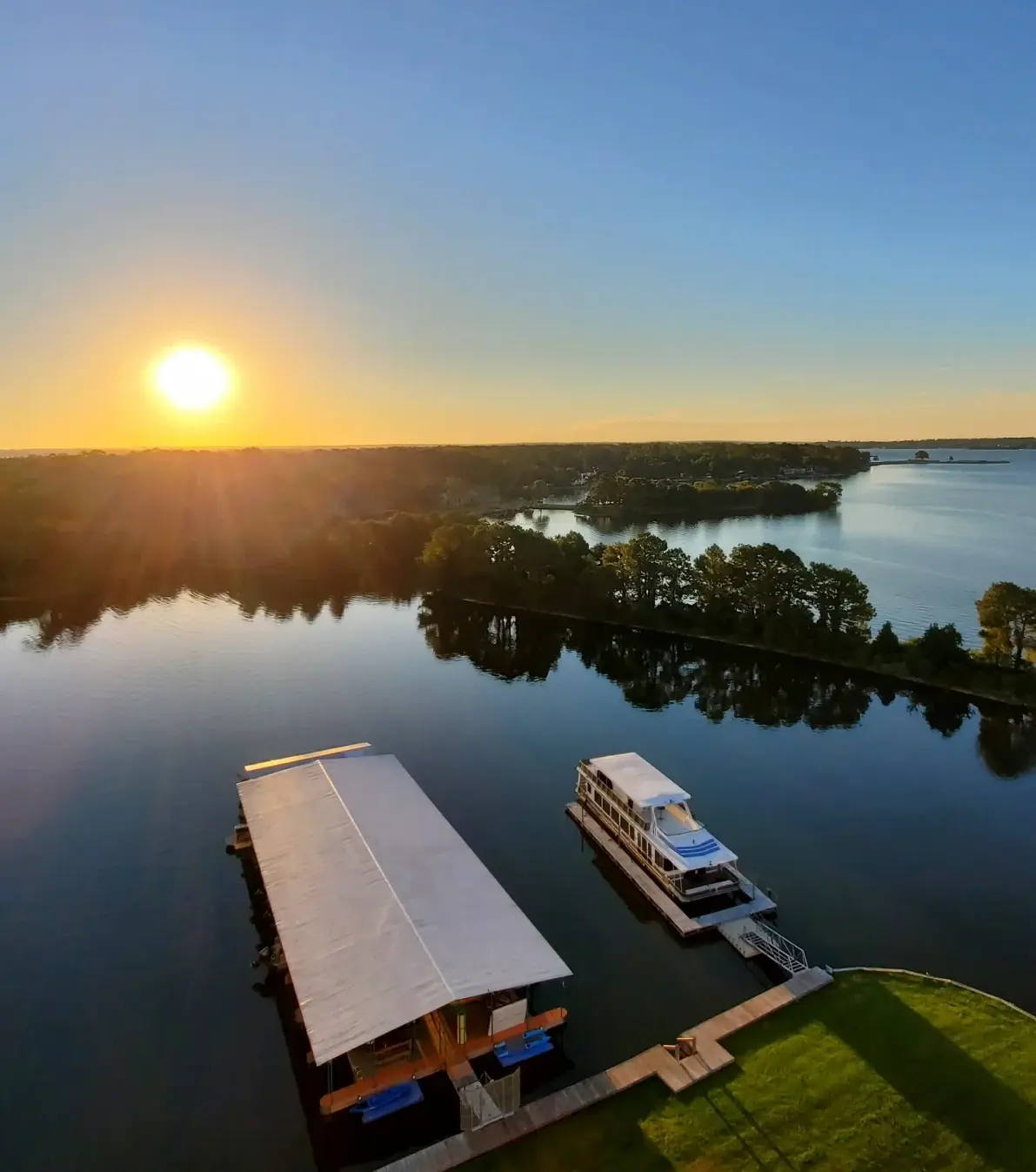 Sunset over a Calm Lake with a Tree lined Horizon a Covered Dock and a Small Boat Moored at a Dock