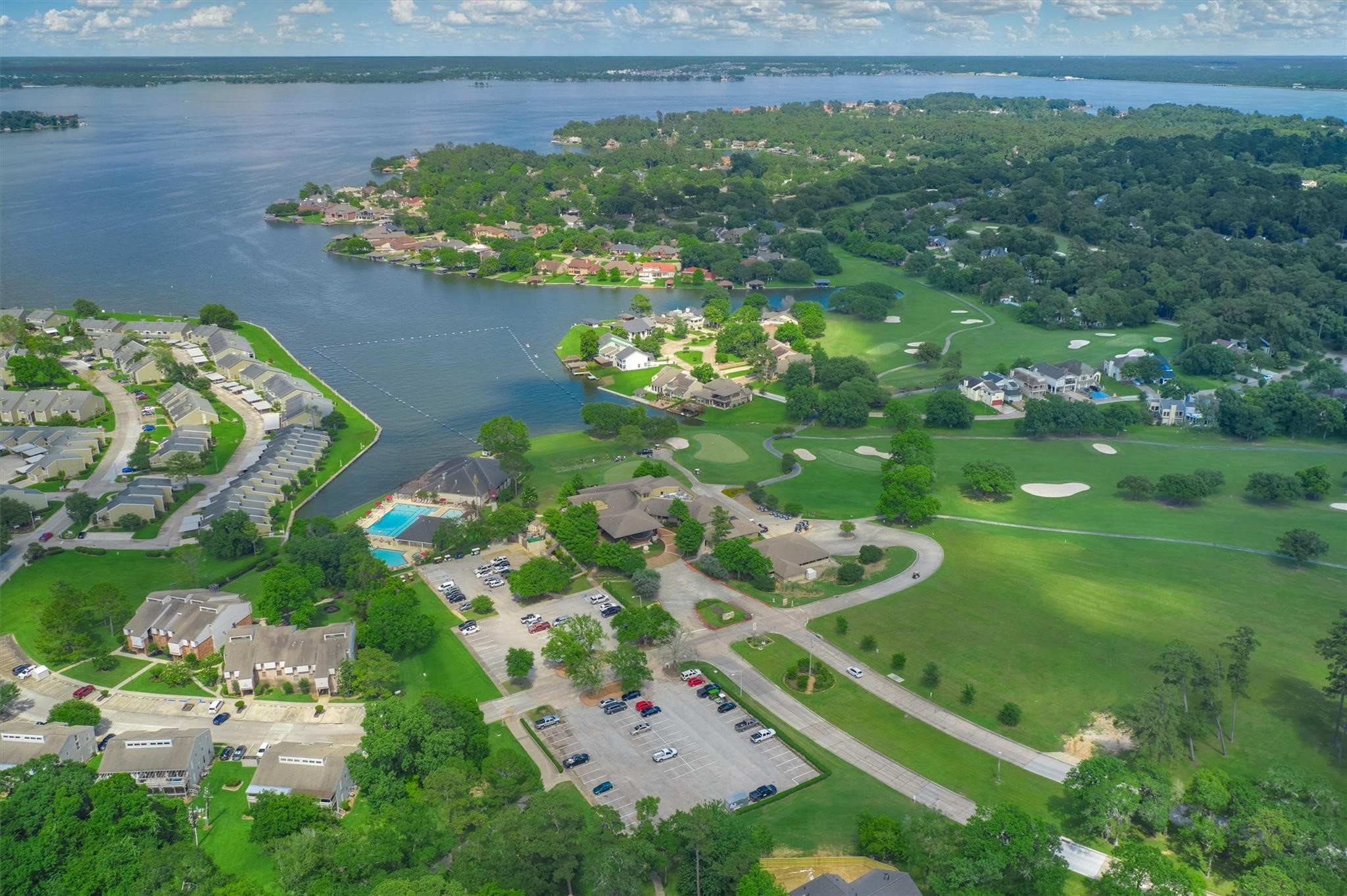 | the mckellar group Aerial View of a Lakeside Suburban Neighborhood with Houses Along the Shoreline Green Lawns and a Nearby Golf Course Across the Water