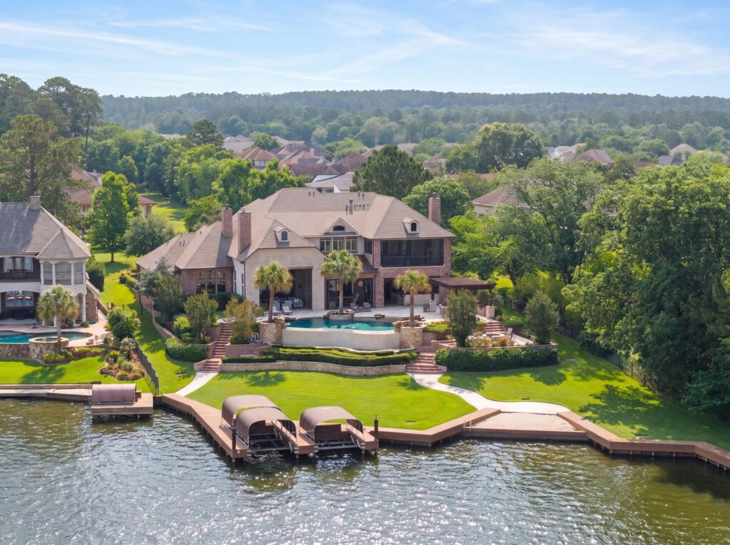 | the mckellar group Aerial View of a Lakeside Neighborhood with Houses Green Lawns and a Dock Along the Water