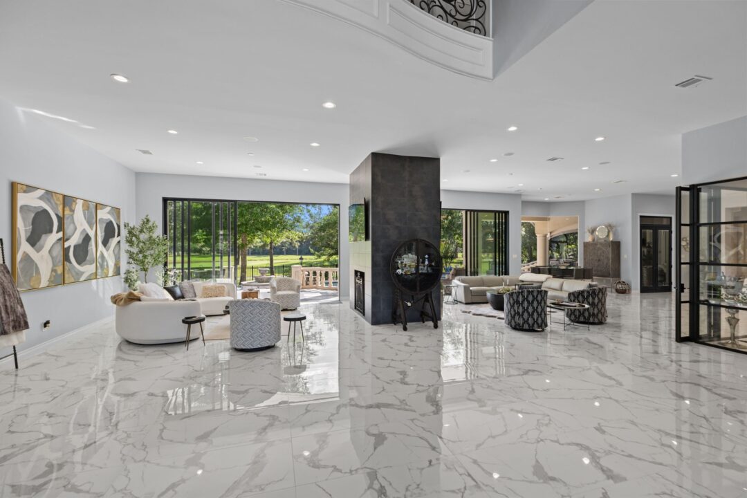 | the mckellar group Bright Modern Living Room with White Marble Floors Gray Walls and Expansive Windows Looking out on a Green Lawn and Trees