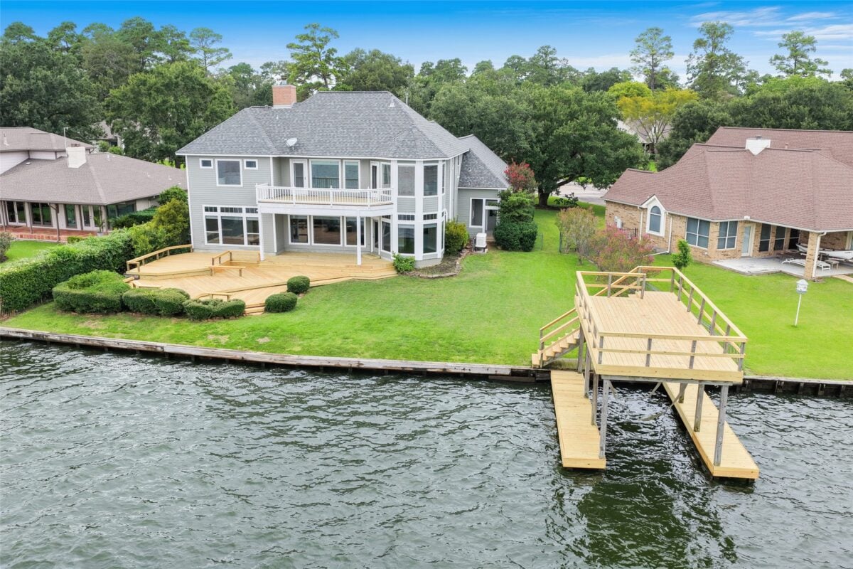 Default | the mckellar group Waterfront Suburban Home with a Large Wooden Deck and Dock Along a Canal or Lake Surrounded by Green Lawns and Trees