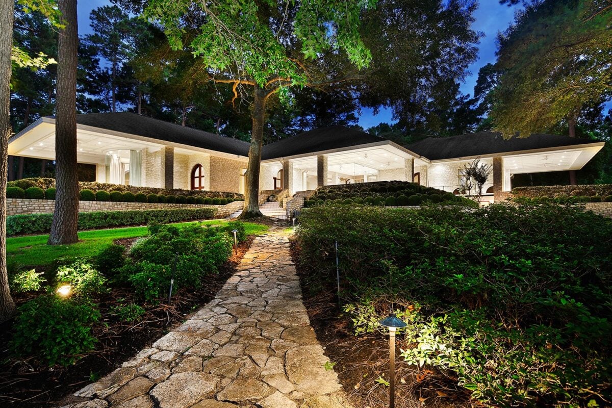 Hardscaping tips for a functional and beautiful lakefront property | the mckellar group Natural Stone Walkway with Lighting and Shrubbery Leading to a Luxurious High End Home in the Evening