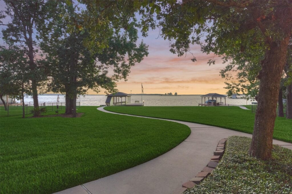 | the mckellar group Sunset over a Lake Viewed from a Grassy Park with a Curving Path and Two Gazebos by the Water